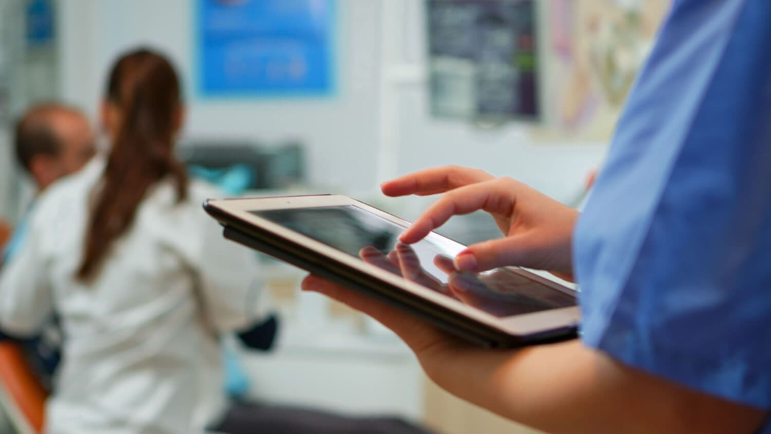 aplikacja pacjenta, lekarz trzymający tablet i uzupełniający dane w aplikacji