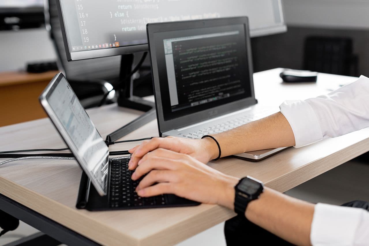 developer pracujący na kilku ekranach i urządzeniach jednocześnie 