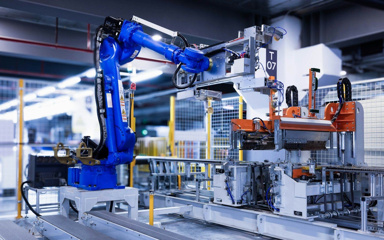 Niebieskie ramię robota przemysłowego na linii produkcyjnej