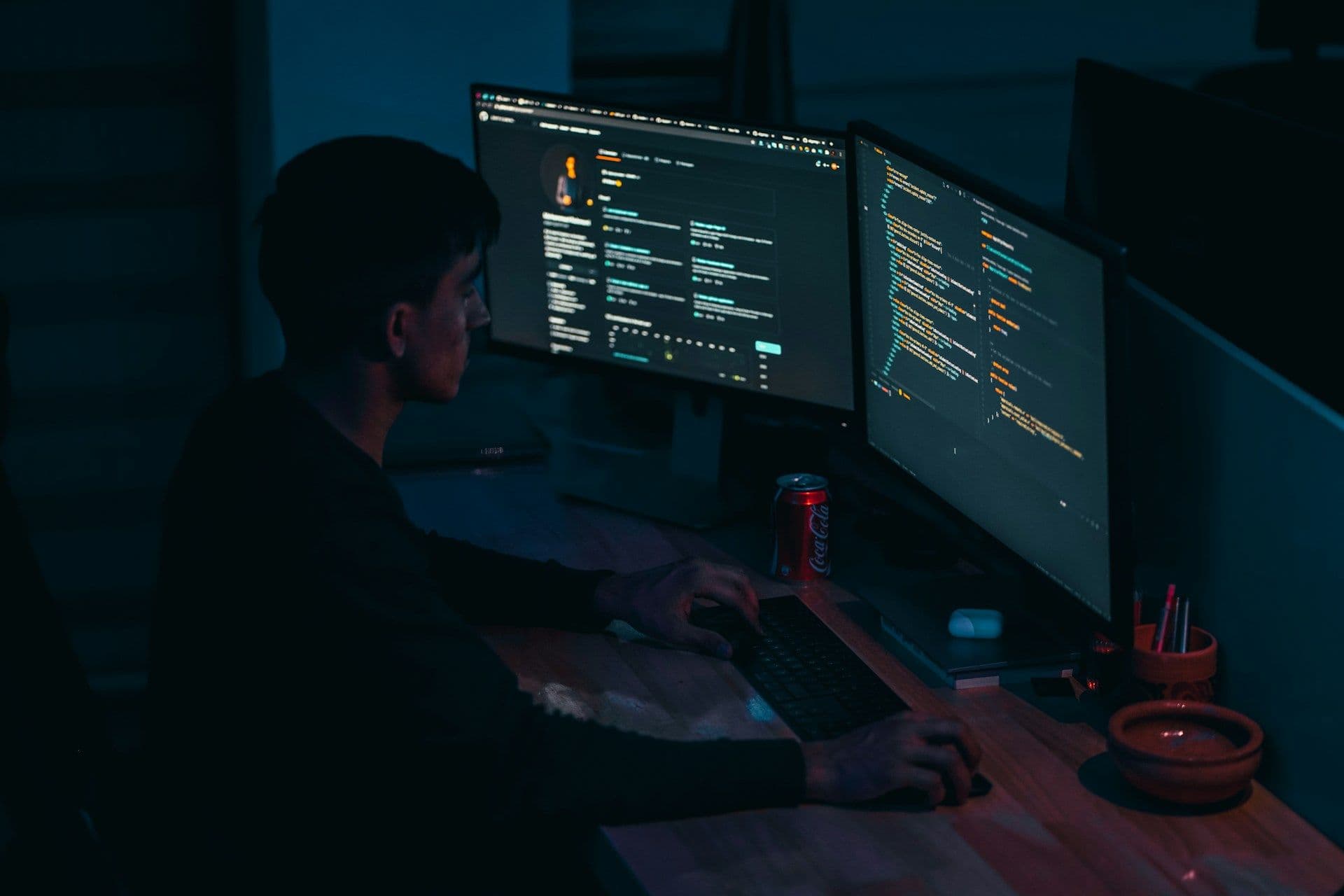 developer pracujący z kodem w zaciemnionym pokoju 